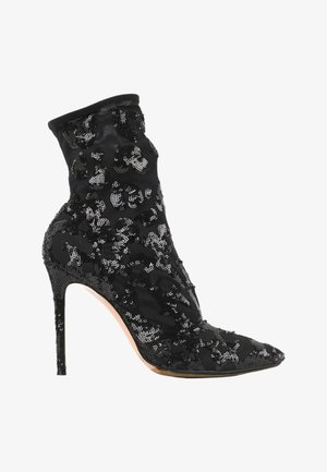 Bottine noire à talon haut recouverte de sequins noirs avec un bout pointu et un talon aiguille.