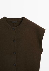 Brown sleeveless cardigan with a round neckline, featuring four black buttons down the front and ribbed edges. Soft knit texture.