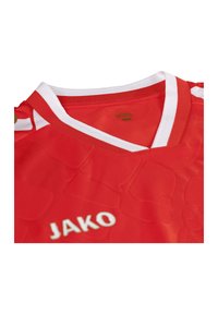 Maillot de sport rouge avec des accents blancs, à manches courtes et design en V. Présente une texture en relief et le logo "JAKO" en blanc.