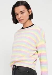 Πλεκτό πουλόβερ με πολύχρωμες οριζόντιες ρίγες σε παστέλ αποχρώσεις (ροζ, μπλε, κίτρινο), στρογγυλή λαιμόκοψη και υφασμάτινη υφή.