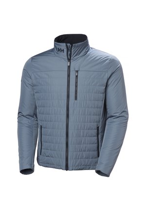 Chaqueta aislante azul claro con frente acolchado, cremallera completa, bolsillos en el pecho y laterales con cremallera, y cuello alto con el logotipo "HH".