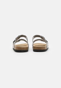 Sandales en cuir gris avec bout ouvert, trois sangles réglables, semelle en liège et semelle extérieure en caoutchouc. Forme contournée pour le confort.