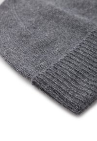 Gorro de punto gris con un acabado suave y texturizado. Cuenta con un puño acanalado y un cuerpo liso, mostrando distintos tonos de gris.