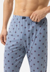 Herenboxers in blauw en witte strepen, met kleine rode bloemenpatronen. Elastische tailleband met merketiket. Zachte katoenen stof.