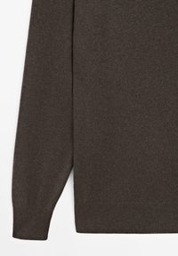 Mörkbrun stickad tröja med rund halsringning, långa ärmar och ribbstickade muddar och fåll. Mjuk textur, minimalistiskt mönster och inga synliga detaljer i metall.