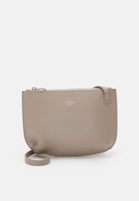 Bolso tipo pouch de cuero beige con textura lisa, cierre de cremallera y una correa en un lado. Presenta el logo "Copenhagen Studios" en el frente.