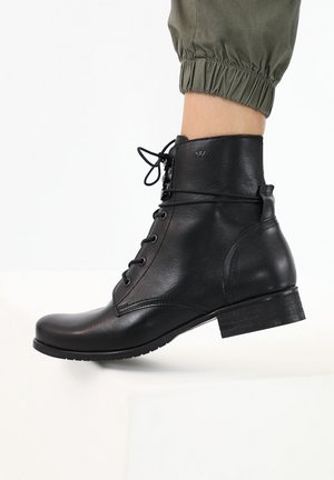 Black leather ankle boot with a rounded toe, laces, and a low block heel. Features a smooth finish and stitching details along the sides.