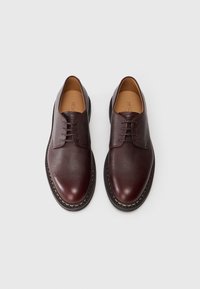 Burgunderfarbene Lederschuhe mit strukturiertem Finish, runder Spitze und vier Ösen für Schnürsenkel. Mit einer kontrastierenden genähten Sohle.