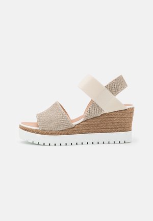 Beige flettet kile-sandal med elastisk ankelrem, platform dækket med jute og hvid rillede gummisål.