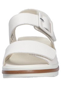 White sandal with two adjustable straps in textured material, featuring a buckle accent. Designed with a cushioned sole and a slight heel.