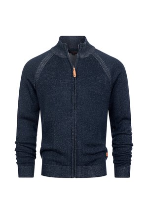 Marineblauwe trui met ritssluiting, hoge kraag, geribbelde structuur en een contrasterend gespikkeld patroon. Heeft lange mouwen en een klein merktekenteken.