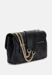 Schwarze gesteppte Handtasche mit goldener Kettenakzent, ausgestattet mit einem Reißverschluss und einem flachen Tragegurt. Strukturleder verleiht eine feste Form.