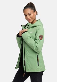 Žalia izoliuota striukė su gobtuvu, užtrauktukais kišenėmis ir juodais akcentais. Ant rankovės yra ruda logotipo etikete ir lygi tekstūra.