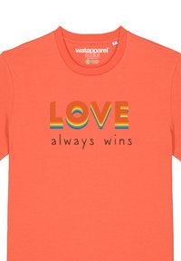 Koraalkleurig katoenen T-shirt met de tekst "LOVE always wins" in gelaagde, meerkleurige letters en een ronde halsdesign.