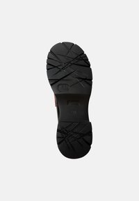 Suola di scarpa in gomma nera con profonde scanalature e superficie texturizzata; presenta il marchio X30 e una scanalatura centrale per la flessibilità.