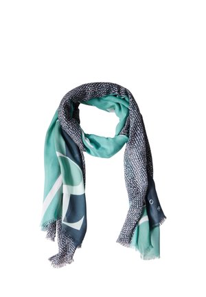 Écharpe rectangulaire douce avec des motifs abstraits en turquoise, marine et blanc, pliée lâchement avec des bords à franges.