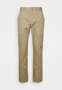 Straight-cut beige work pants with reinforced knee patches and a small logo patch on the right leg against a white background.