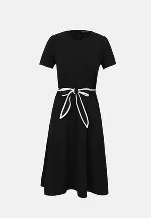 Robe noire longueur genou avec manches courtes et ceinture blanche nouée à la taille, avec un col rond et une fermeture éclair au dos.