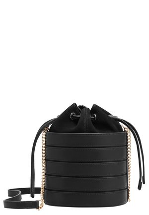 Sac seau en cuir noir avec un corps texturé, une fermeture à cordon et une bandoulière chaîne dorée. Présente des rayures horizontales à l'extérieur.