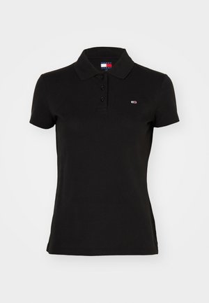 Polo shirt noir en coton, avec un col, trois boutons et un petit logo brodé sur la poitrine. Manches courtes.