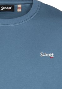 Felpa azzurra chiara in cotone, con scollatura a coste e logo ricamato "Schott NYC" in bianco con accento rosso. Taglia L.
