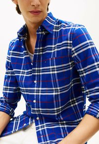 Blauw geruite overhemd met witte en rode lijnen, met een button-down kraag, lange mouwen en een borstzak met een klein logo-detail.