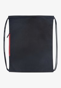 Μαύρη υφασμάτινη τσάντα ώμου με λείο υφή, που διαθέτει κόκκινη τσέπη με φερμουάρ στη μία πλευρά και δύο ρυθμιζόμενους ιμάντες ώμου.