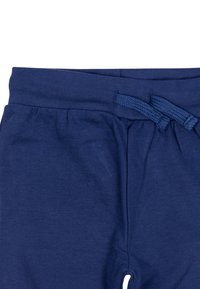 Navyblaue Baumwoll-Sweatpants mit einem Kordelzugbund, der eine geraffte Textur entlang des Bundes und seitliche Taschen aufweist.