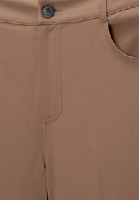 Hnědé kalhoty vyrobené z hladké látky, s jedním černým knoflíkem, předními kapsami a jemně prošívanými detaily podél švů.