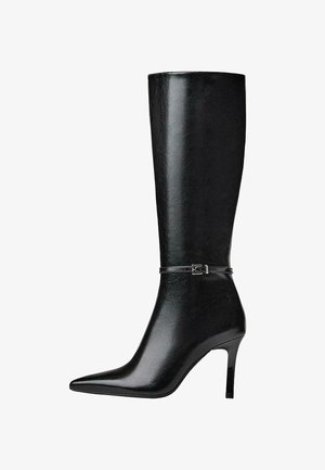 Schwarzer kniehoher Stiefel aus glänzendem Leder mit spitzer Schuhspitze und schlankem Absatz. Verfügt über einen dünnen Riemen mit einer kleinen Schnallendetail.