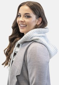 Pulover din lână gri, cu o glugă mare tricotată de culoare gri deschis, decorată cu un model în dungi. Designul este ajustat, având un aspect minimalist și curat.