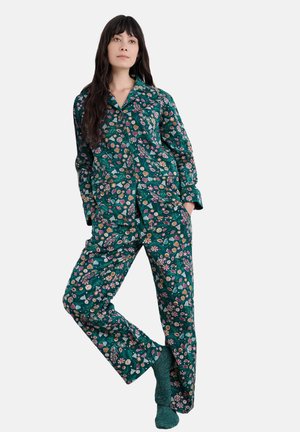 Bloemenpatroon pyjama's in diep groen, met een knoopsluiting overhemd en losse broek met een zachte textuur. Gecombineerd met gebreide sokken.