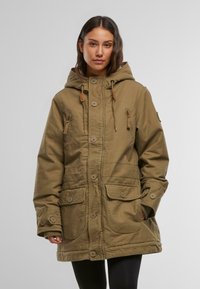 Giacca parka verde oliva con cappuccio, chiusura con bottoni, due grandi tasche frontali, cuciture a vista e cordini regolabili al collo.