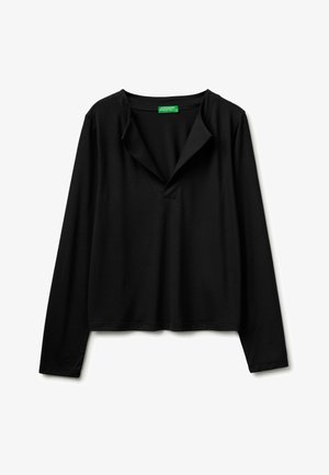 Czarna koszula z długim rękawem, z otwartym kołnierzem w serek i zieloną metką wewnątrz kołnierza, ułożona płasko na białym tle.