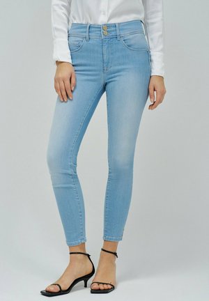 Lichtblauwe skinny jeans met voorzakken, een sluiting met twee knopen en een slim fit. Gestyled met zwarte open teen hakken.