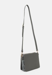 Borsa a tracolla grigia con un esterno liscio e dettagli in stampa rettile testurizzata, dotata di tracolla regolabile e accenti in metallo dorato.