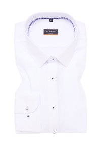 Camicia bianca slim fit piegata con cura, dotata di colletto classico, davanti con bottoni e polsini a doppio bottone.