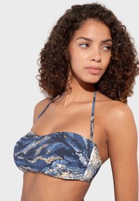 Biely a krémový vzorovaný bikiny top s bandeau dizajnom, s tenkými nastaviteľnými popruhmi a textúrovanou tkaninou.