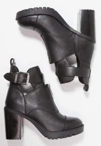 Czarne botki za kostkę z teksturowaną skórzaną cholewką, masywnym obcasem, szczegółami z klamrą oraz gumową podeszwą z bieżnikiem.