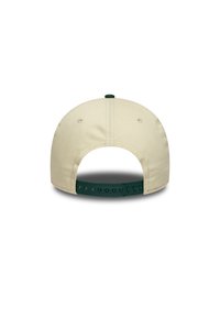 Casquette en tissu beige avec une sangle réglable verte et un bouton sur le dessus. Présente des coutures et des œillets de ventilation pour la respirabilité.