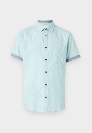 Short-sleeve, light blue shirt made of linen blend, featuring a chest pocket, dark buttons, and contrasting blue cuffs.