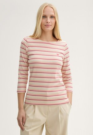 T-shirt à manches longues rayé en crème, rose et rouge. Présente un col rond et un petit logo en forme de cœur sur la poitrine. Tissu doux et léger.