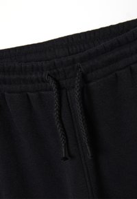 Zwarte sweatpants met een gestructureerde tailleband, trekkoord en zijplooien, gemaakt van een zachte, duurzame stof.