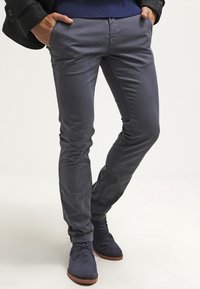 Grijze katoenmengselbroek met een slanke pasvorm, voorzien van een gladde textuur en voorzakken, gecombineerd met marineblauwe suède enkellaarsjes.