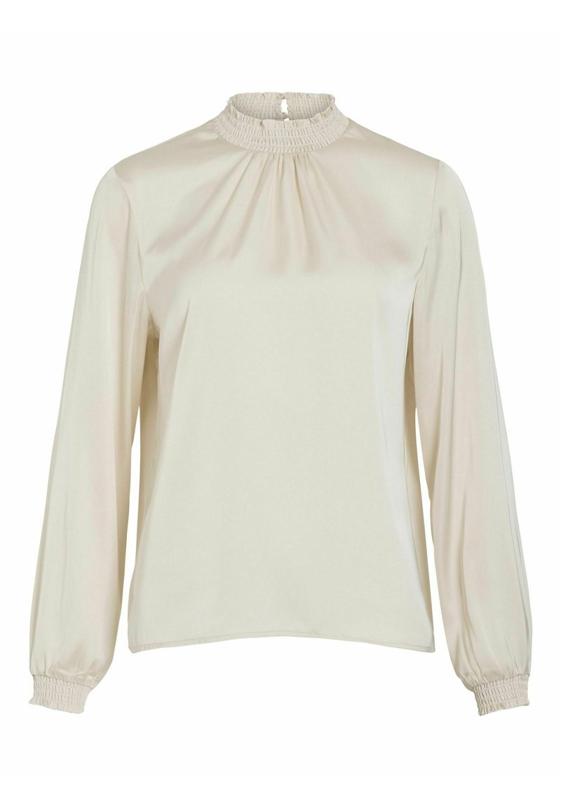 Blouse de couleur crème avec des manches longues, un col froncé et des poignets élastiques. Tissu lisse et brillant avec des plis à l'avant et à l'arrière.