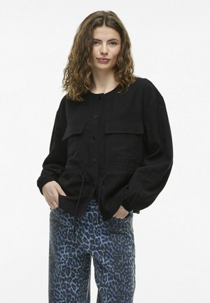 Black, long-sleeve jacket with button closure and two front pockets. Made of textured fabric with a drawstring waist. Paired with blue leopard print pants.