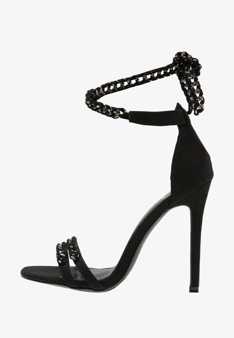 Sandale noire à talons hauts avec une semelle fine, deux brides frontales et une bride de cheville en chaîne tressée noire et argentée.