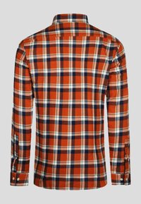 Langsleeve flanellen shirt met een oranje, marineblauwe, witte en beige geruite patroon, gezien vanaf de achterkant op een grijze achtergrond.