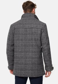 Grijze wolmix jas met een grote kraag, een gestructureerd ruitpatroon, twee zijzakken en een iets oversized pasvorm.