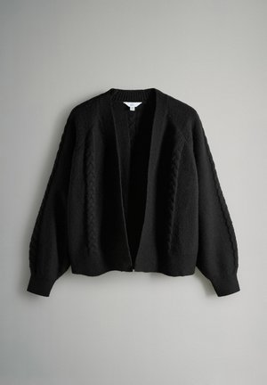 Sort strikket cardigan med kabelmønstre på ærmer og front, åben front og ribbede manchetter og kant.
